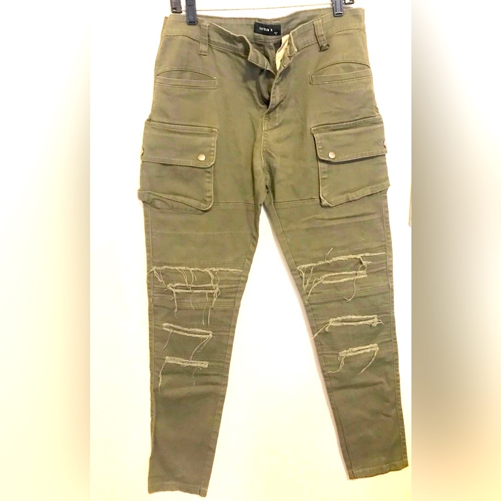 Green mens jeans with rips in front..